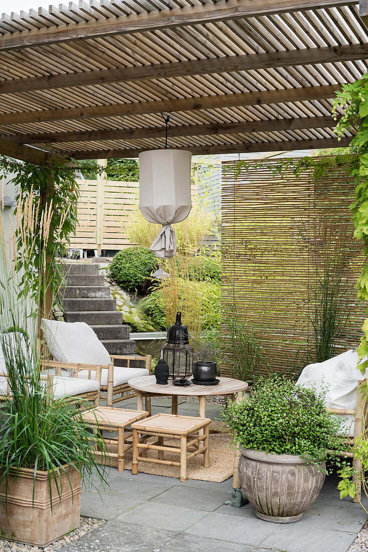 Überdachte Terrasse im asiatischen Stil mit Bambusmöbeln