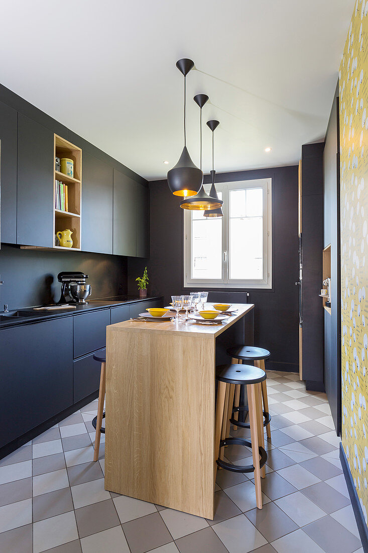 Black designer kitchen with central dining area