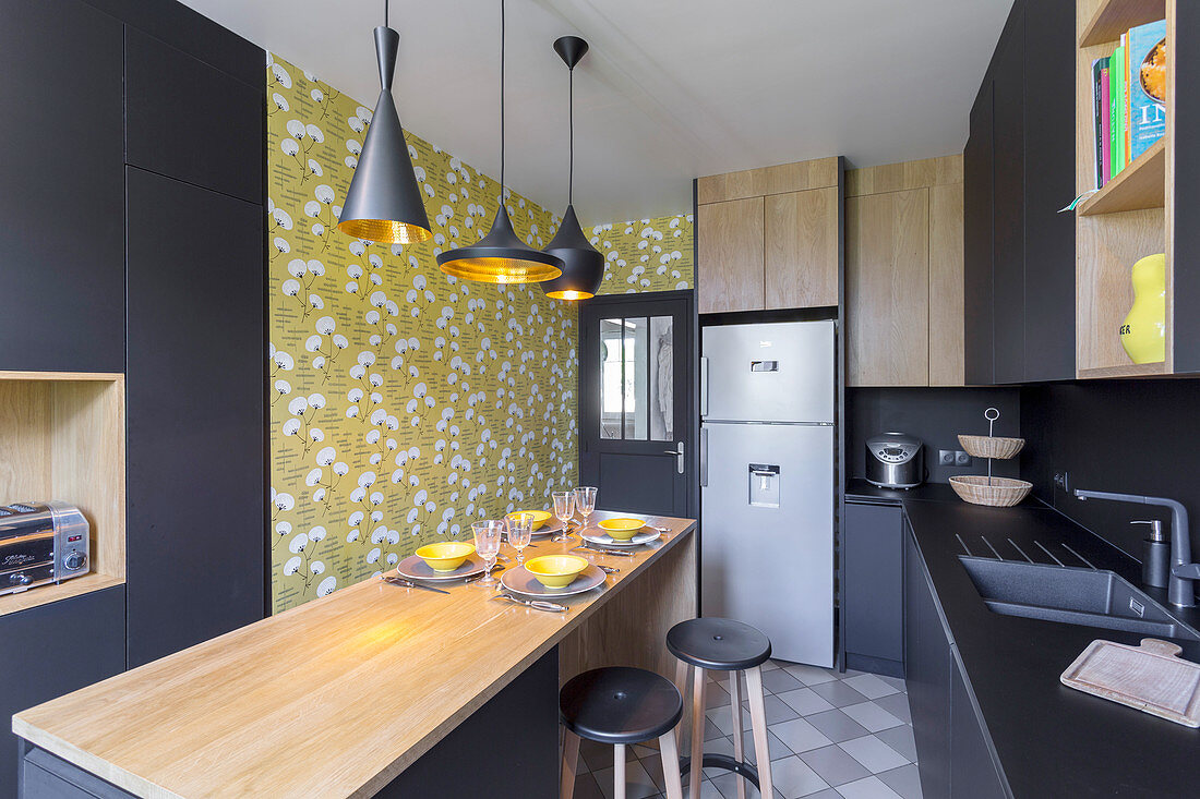 Black designer kitchen with central dining area