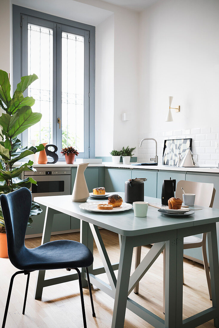 Set folding table in modern kitchen-dining room in blue and white