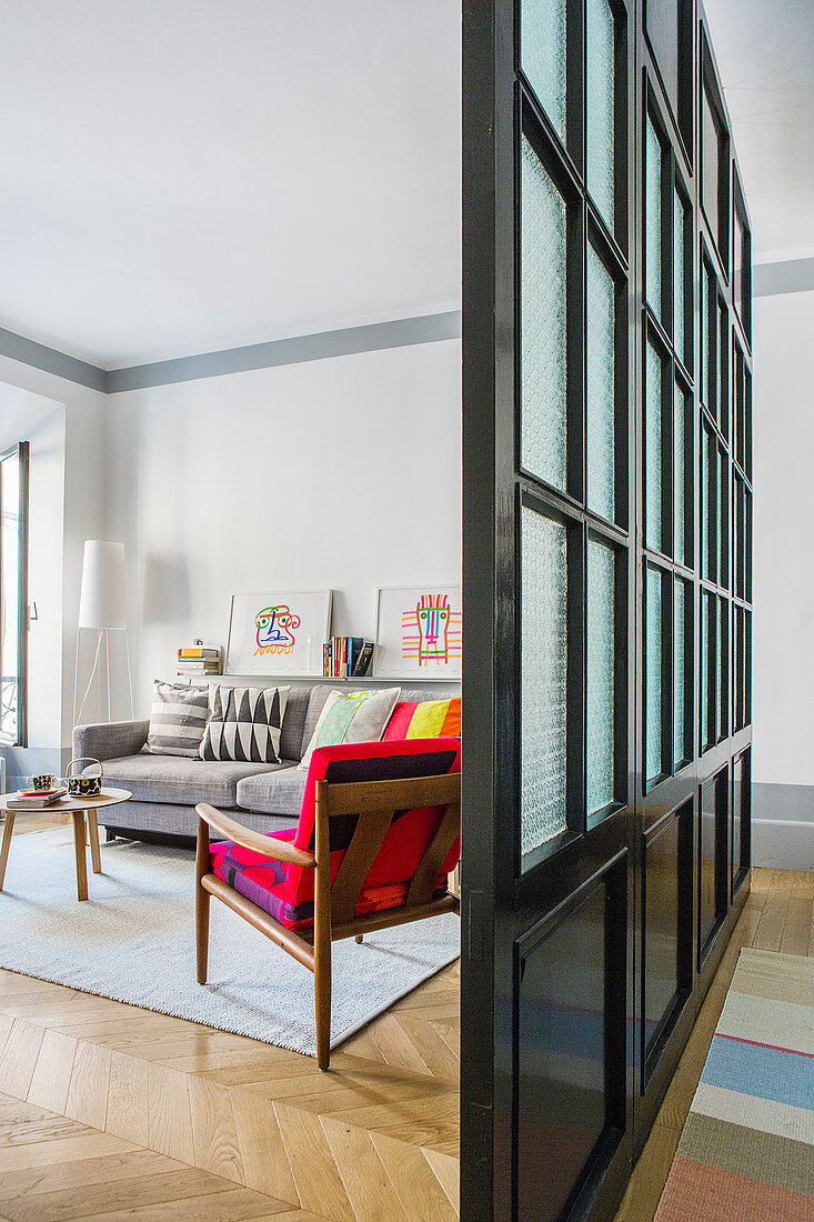 Black lattice and glass partition separating living room