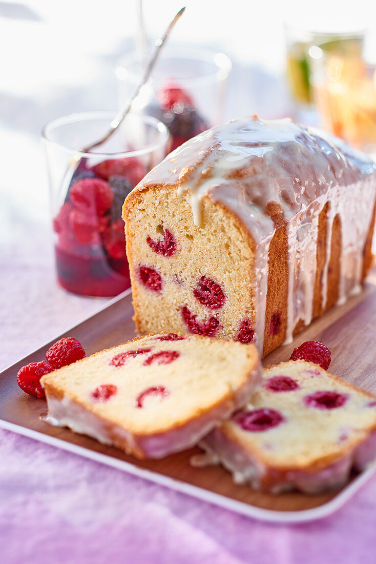 Raspberry loaf cake with icing and a berry salad