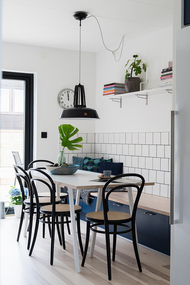 Table with bistro chairs and blue trunk bench in kitchen