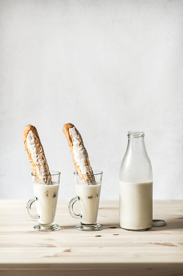 Horchata (tigernut milk) in glasses and bottles with bread sticks