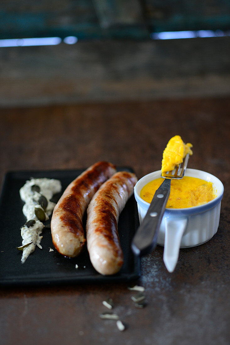 Turkey sausages with a pecorino flan and pumpkin seed sauce