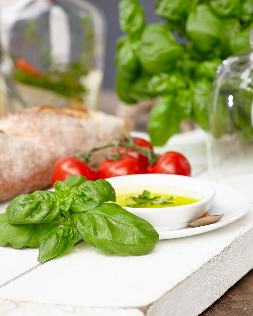 Basilikum, Schälchen mit Olivenöl und Tomaten