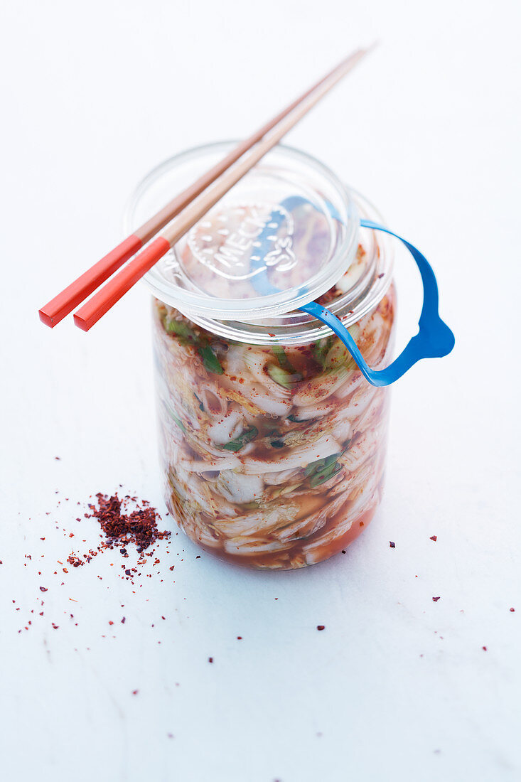 Kimchi in a preserving jar with chopsticks