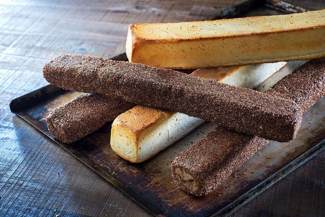 Mehrere Brotstangen auf Backblech, Weißbrot und Vollkornbrot