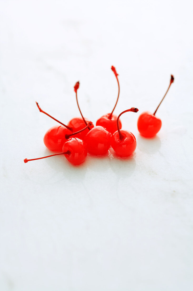 Glacé cherries on a white surface