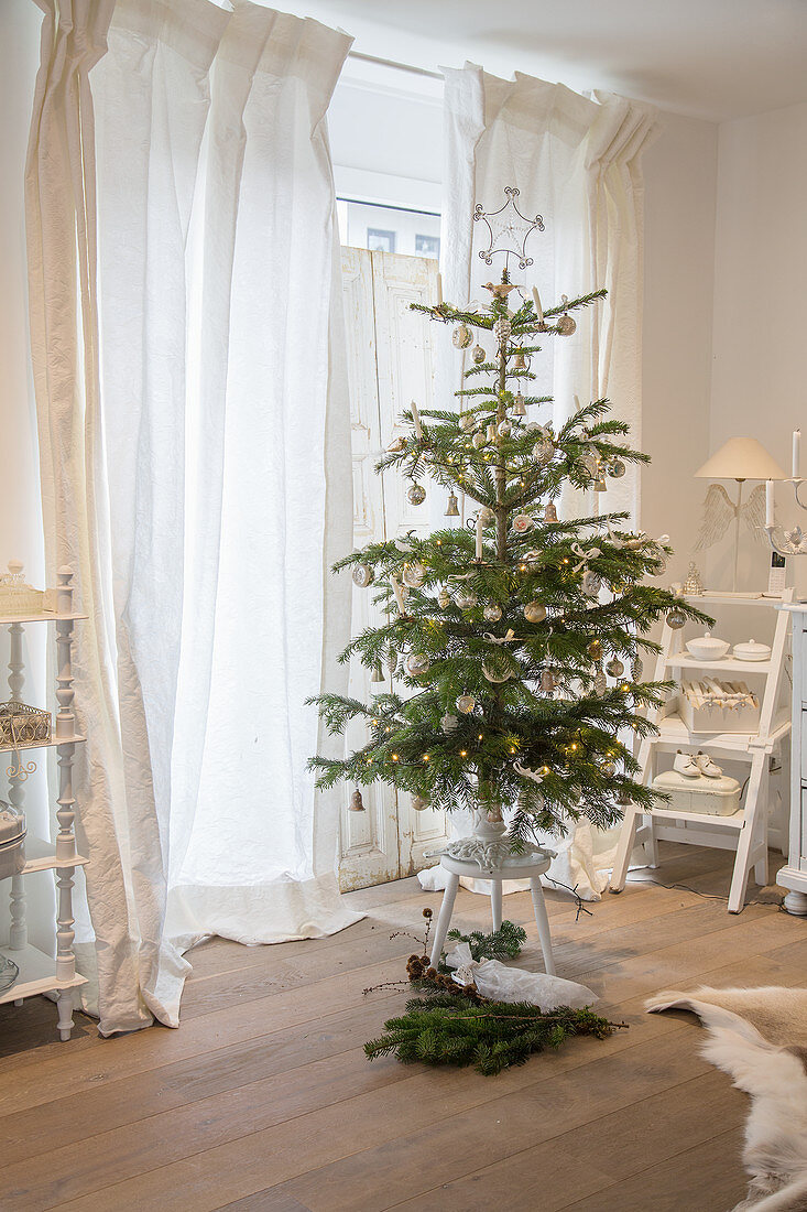 Nostalgisch geschmückter Weihnachtsbaum auf einem Hocker