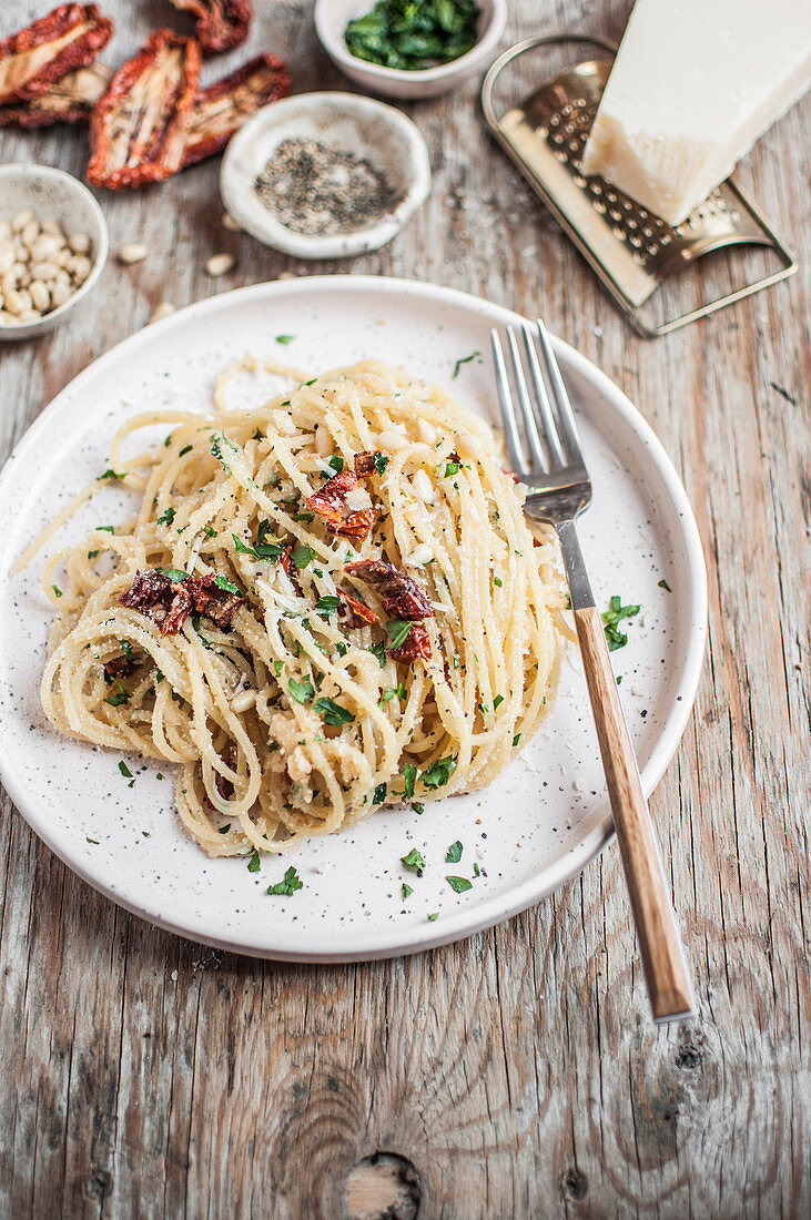 Spaghetti with dried tomatos, parmesan cheese, parsley, pine nuts and pangrattato