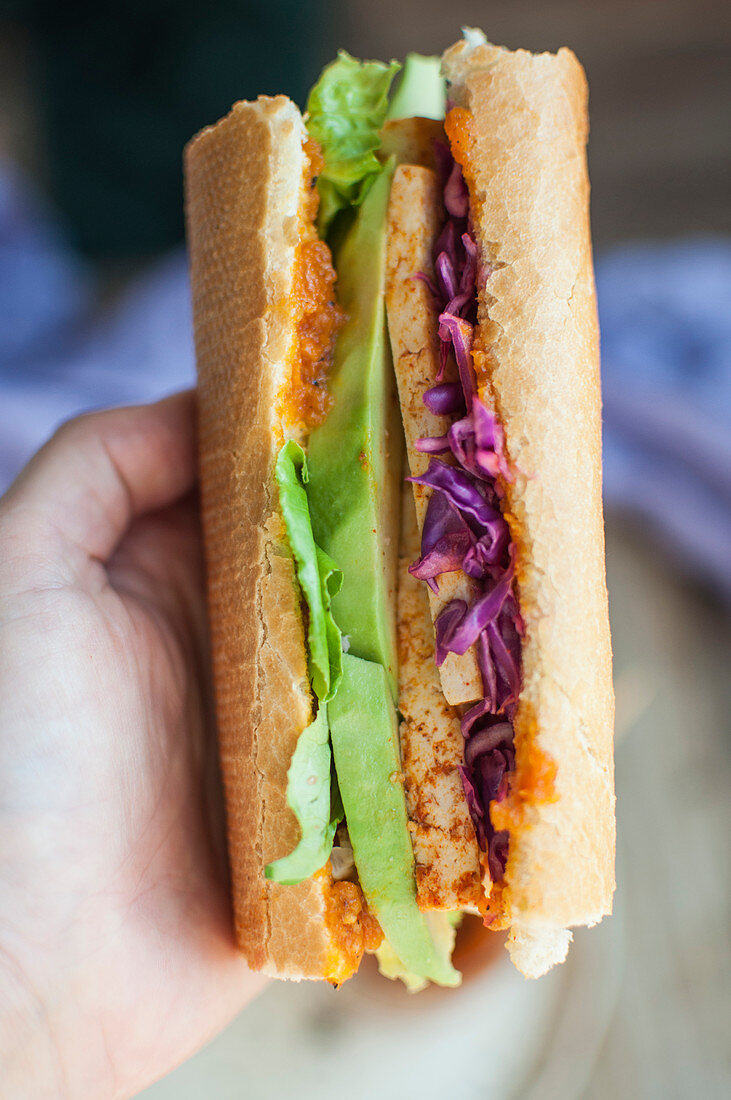 Veganes Baguettesandwich mit Tofu, Avocado, Rotkohl und Karotten-Habanero-Sauce