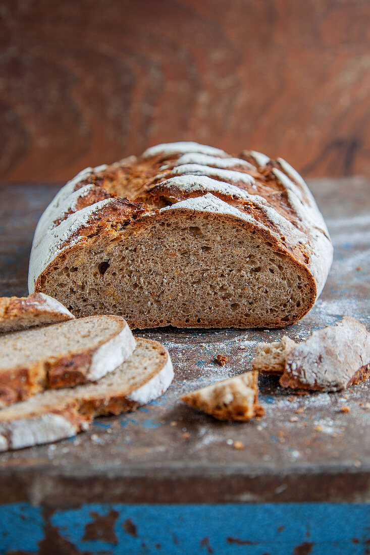 A long loaf of wholemeal sour dough bread, sliced