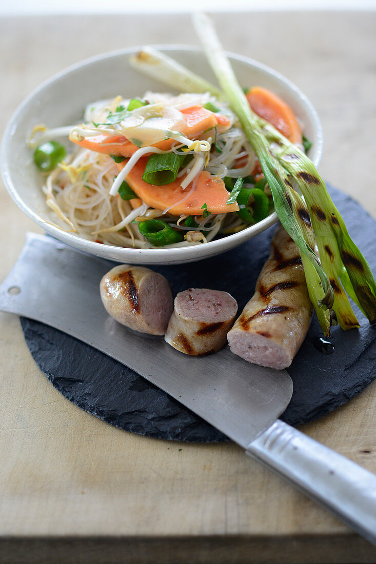 Veal sausages with a papaya and glass noodle salad