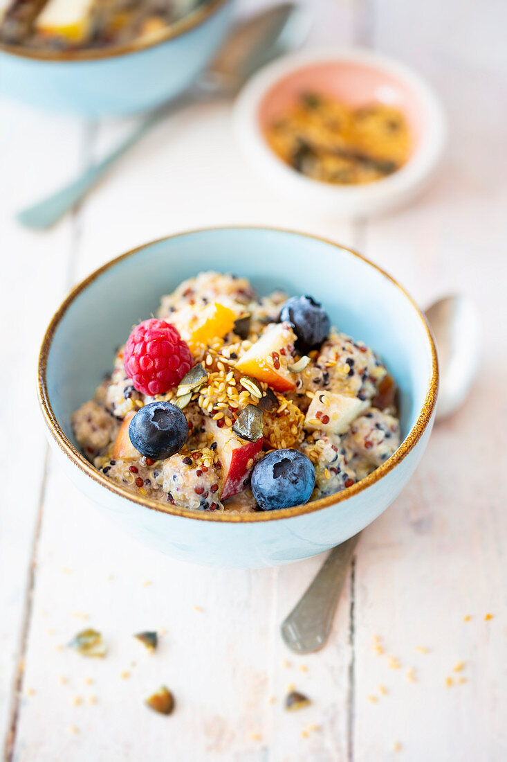 Vegan quinoa muesli with date and cashew cream, fruit and seeds