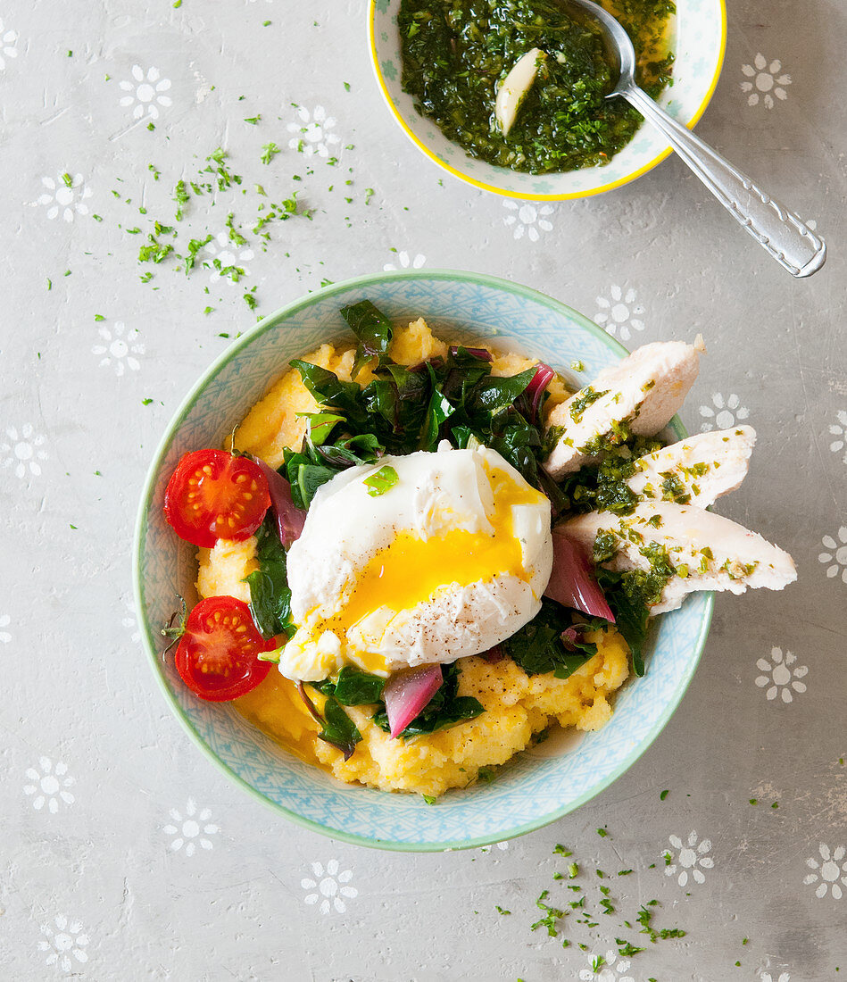 A polenta bowl with chard, a poached egg, turkey and pesto