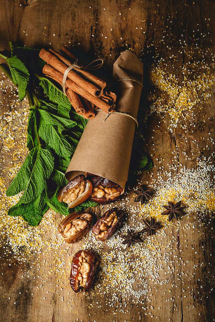 Dates fruits with walnuts, mint and cinnamon muslim halal snack wrapped in paper for Ramadan