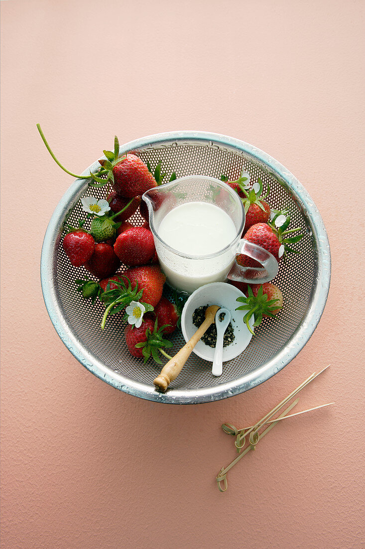 Strawberries with pepper and cream in a sieve