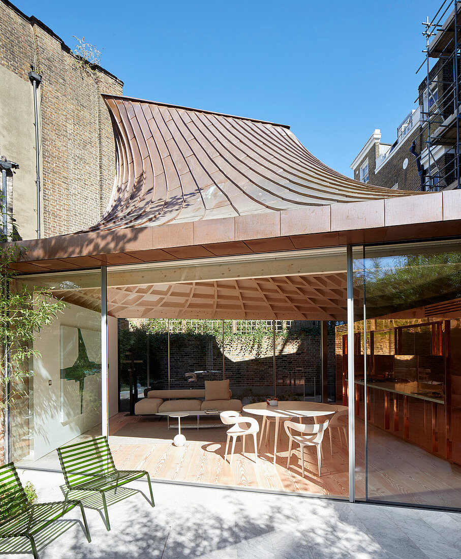 Modern extension with glass walls and funnel-shaped roof