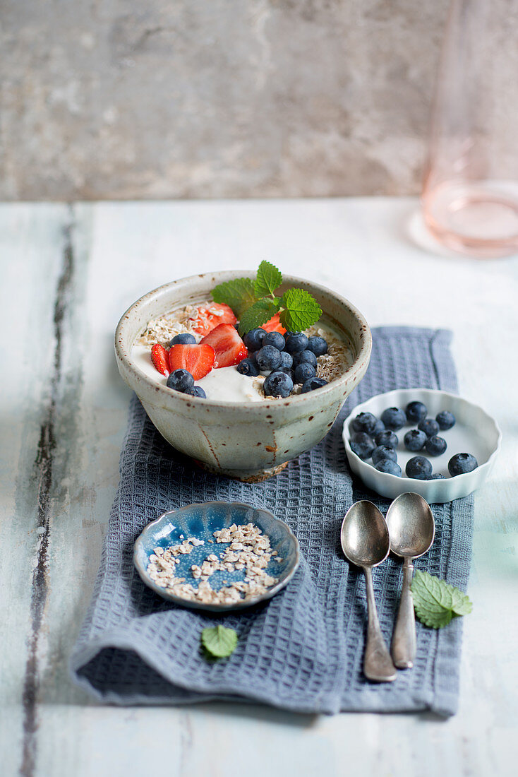Yoghurt with strawberries, blueberries, oats and mint