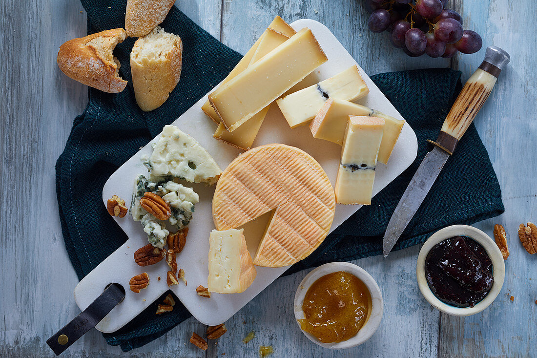 A French cheese platter with nuts, jams and grapes