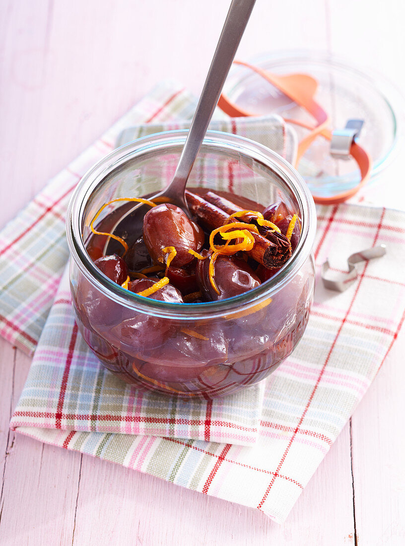 Homemade damson compote with orange zest in a preserving jar