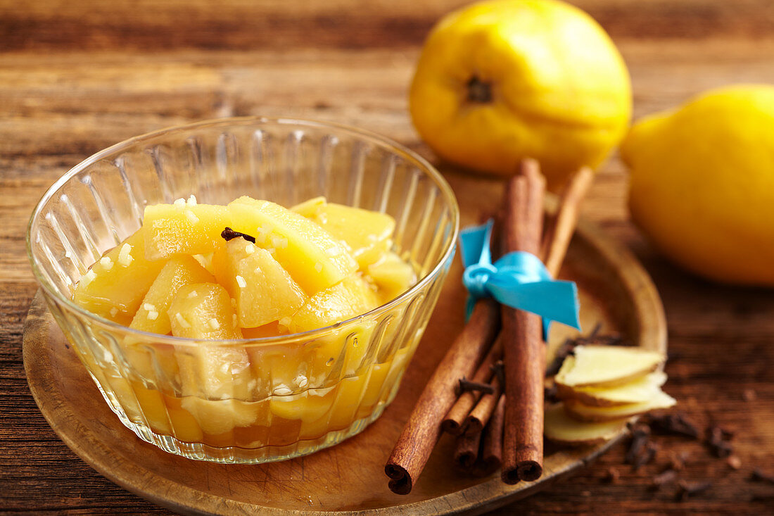 Preserved spiced quinces in a bowl with cinnamon