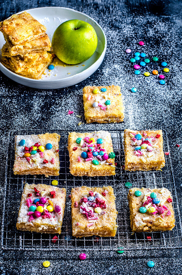 Apple pie cut into squares, decorated with multi-colored candies