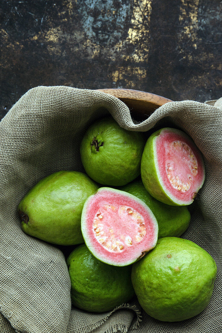Guaven, ganz und halbiert, auf Leinentuch
