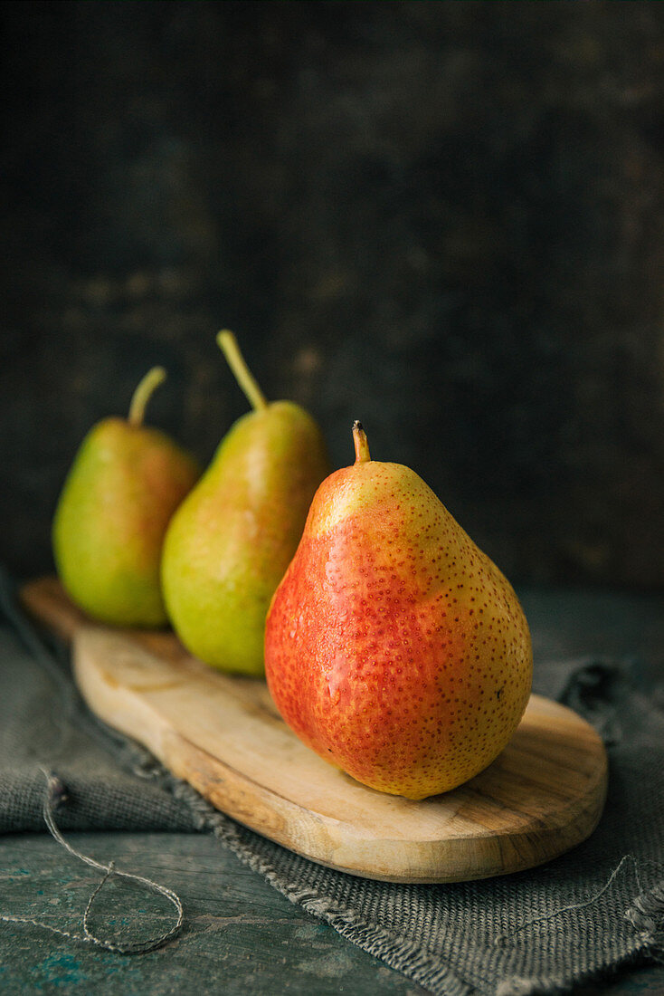Three pears on a wooden board