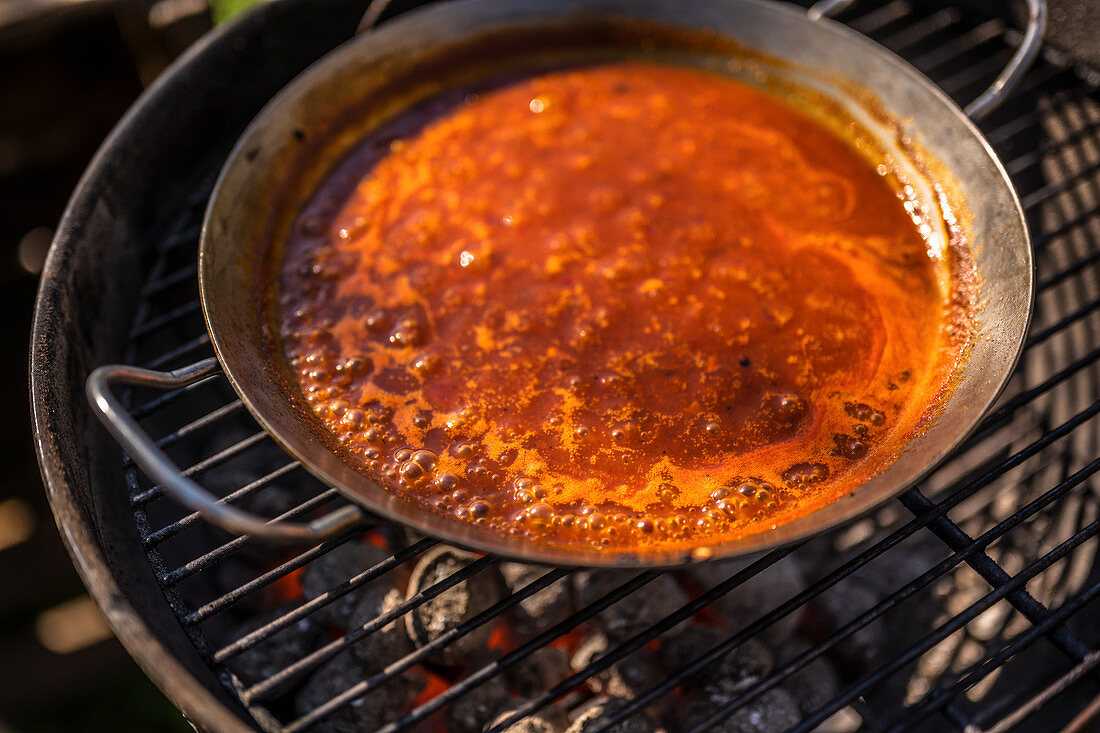 BBQ-Sauce aus Zwiebeln, Tomatenmark, Orangensaft und Whisky zubereiten