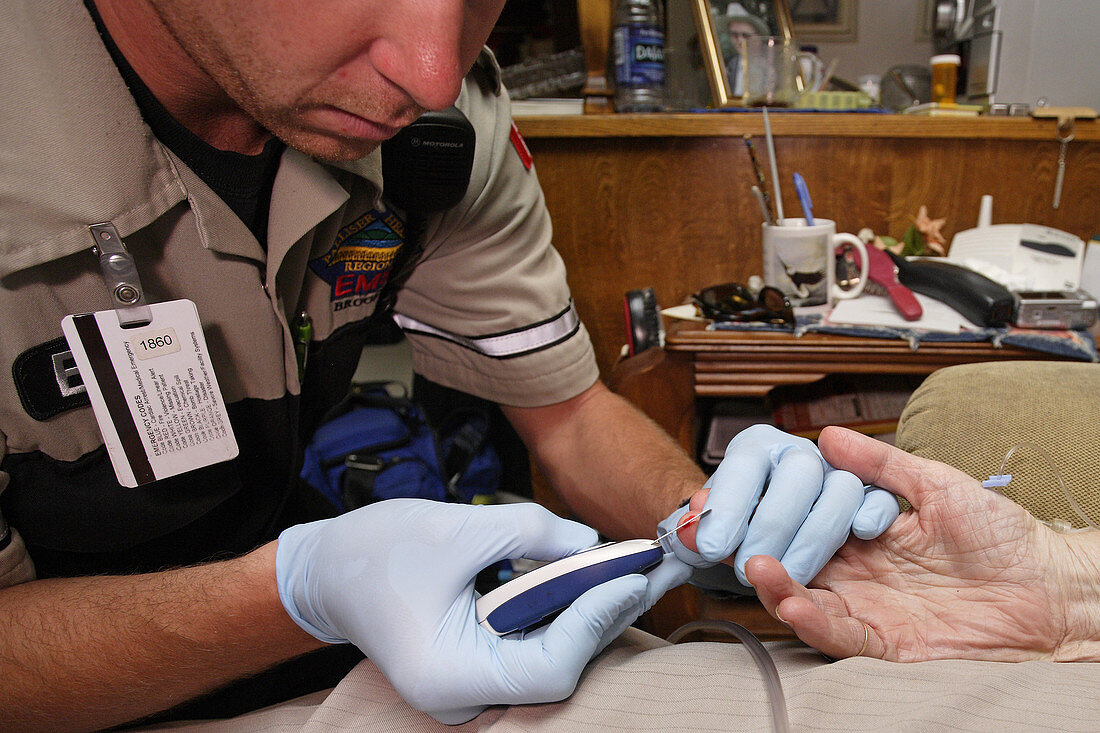 Paramedic Checking Blood Glucose Levels