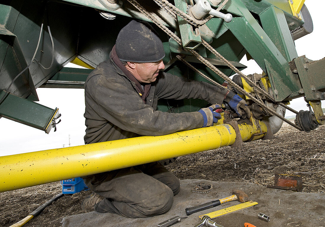 Farmer Repairing Auger on Air Seeder