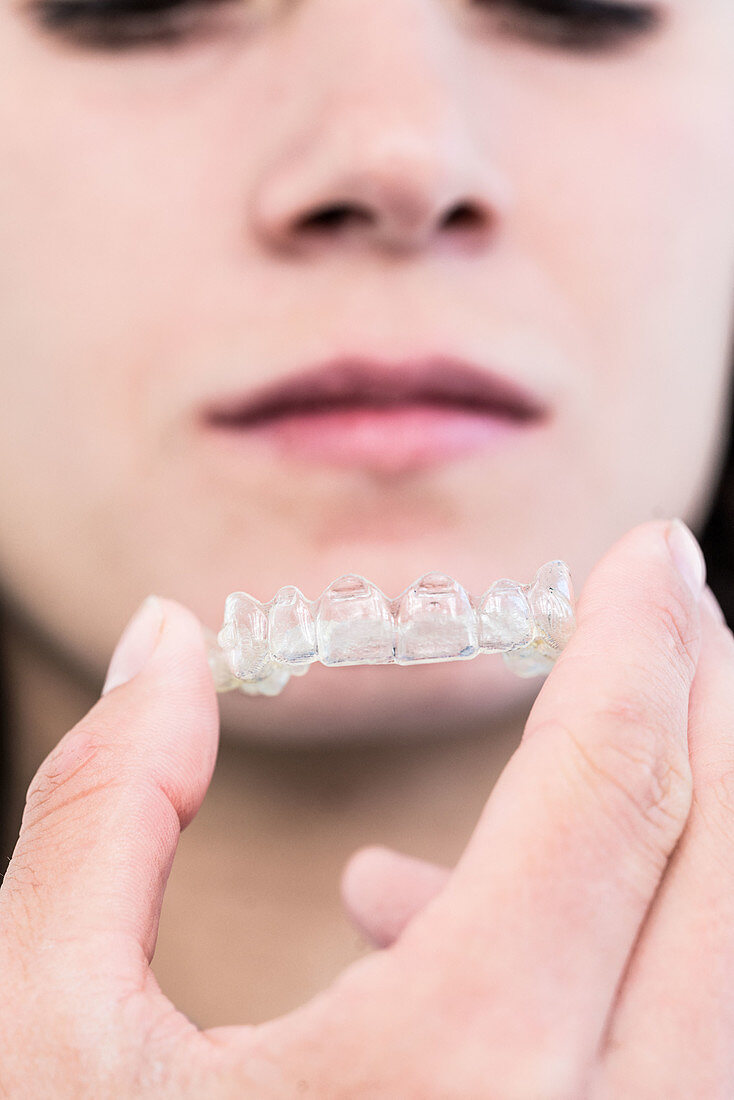 Woman using clear removable teeth aligners