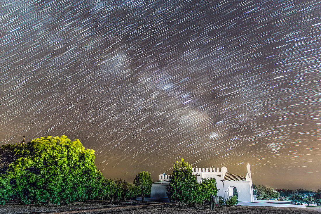 Star trails over chapel, time-exposure image