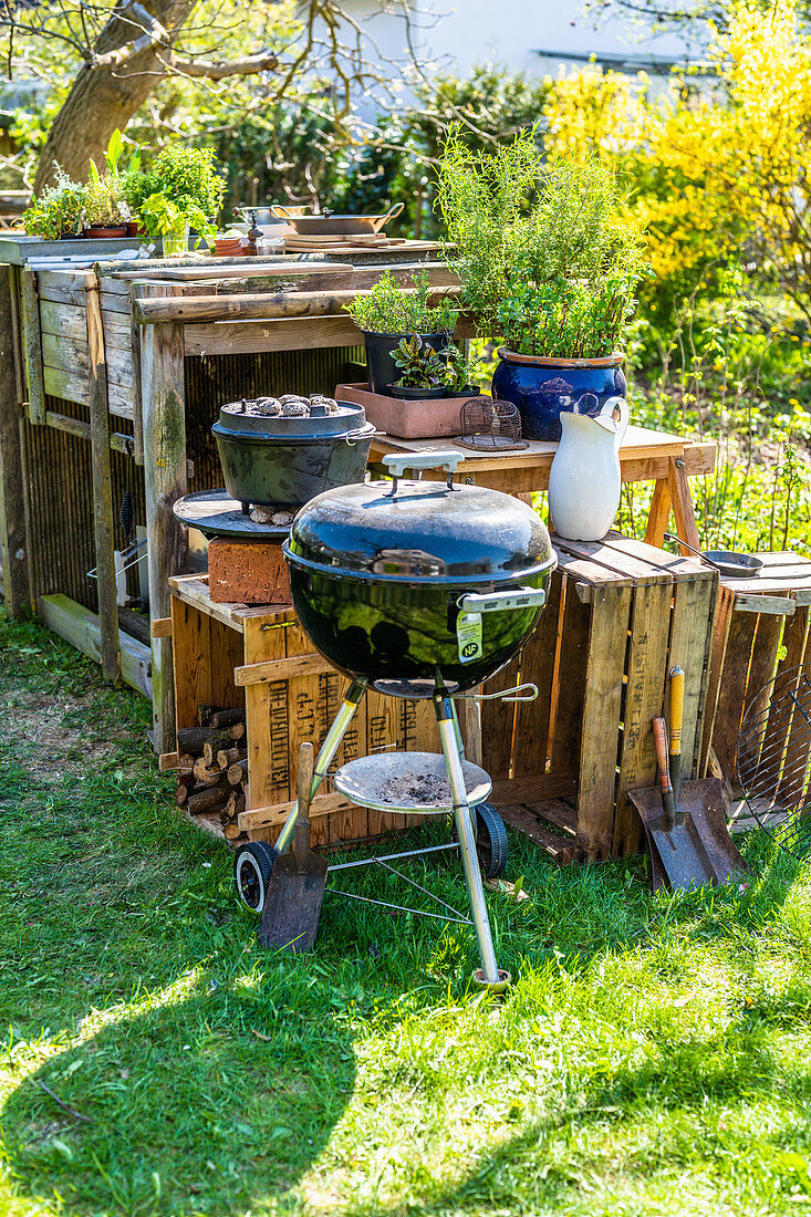 A charcoal barbecue and a Dutch oven in a garden