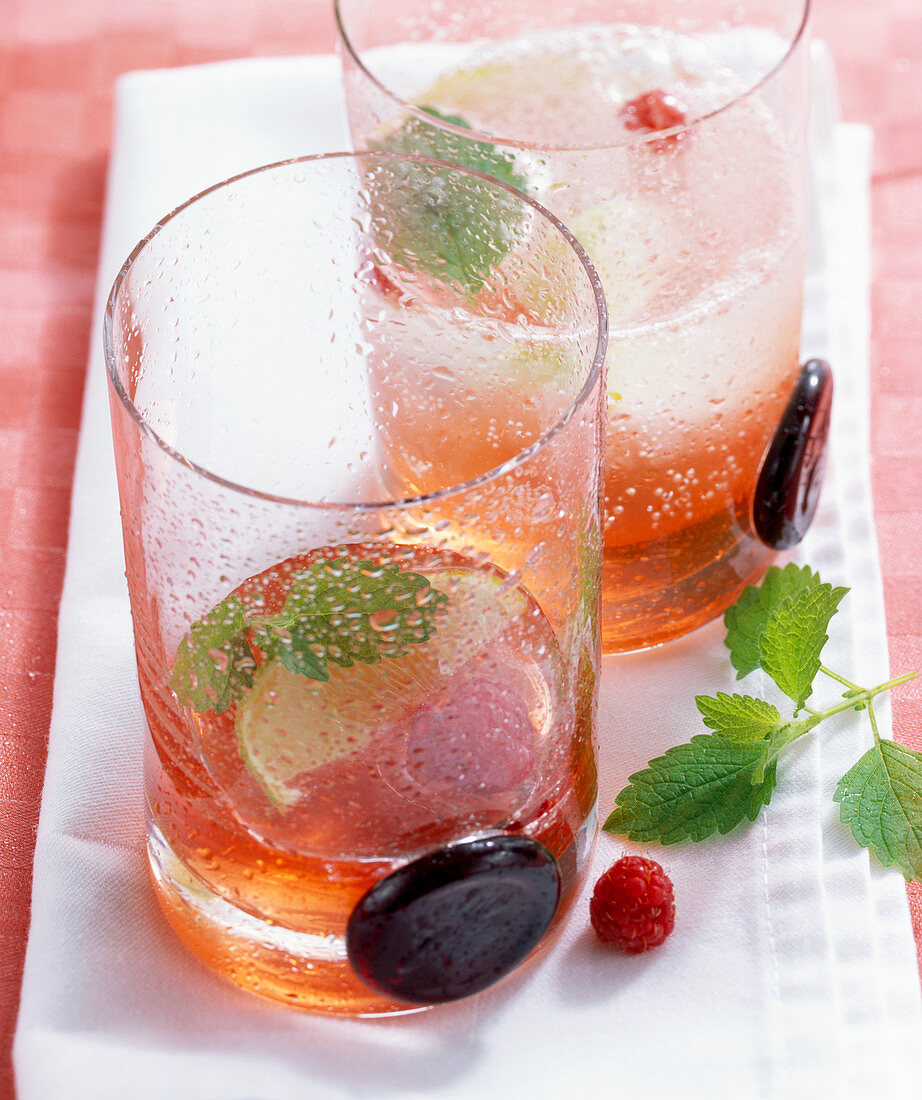 Raspberry syrup with ice cubes and lemon balm