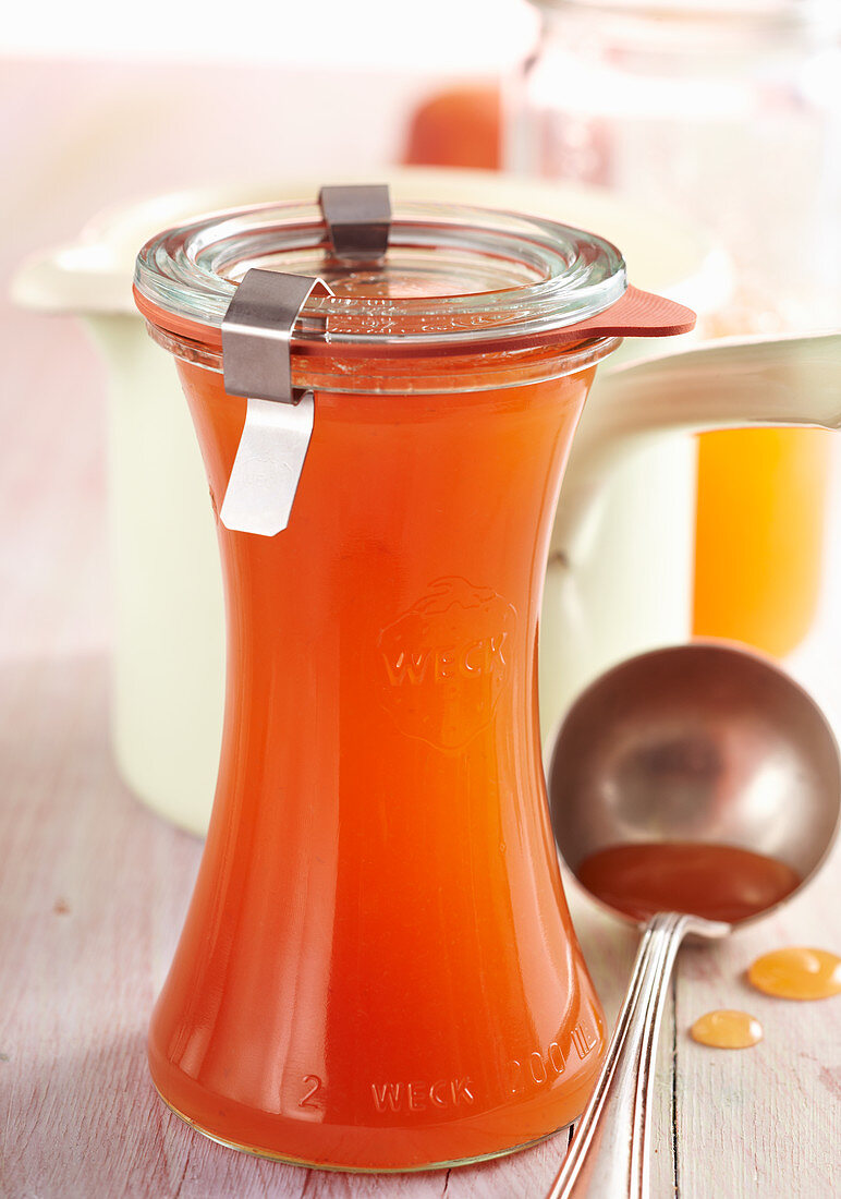 Summery homemade peach syrup in a preserving jar