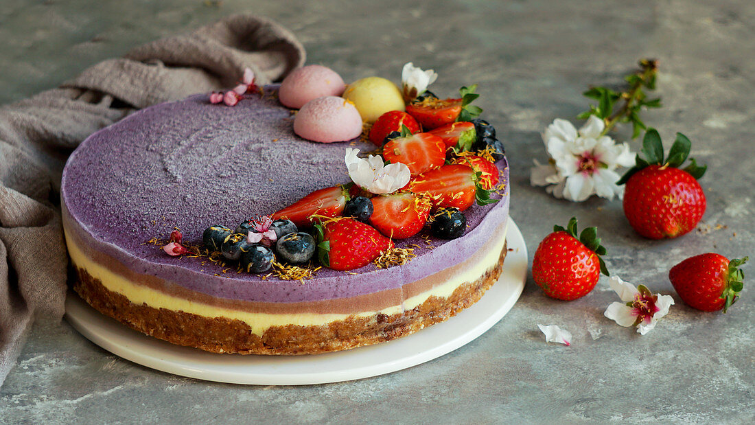 Veganer roher Cashewkuchen mit Beeren, Kokosbutter, Kokosmilch und Mandel-Dattel-Boden