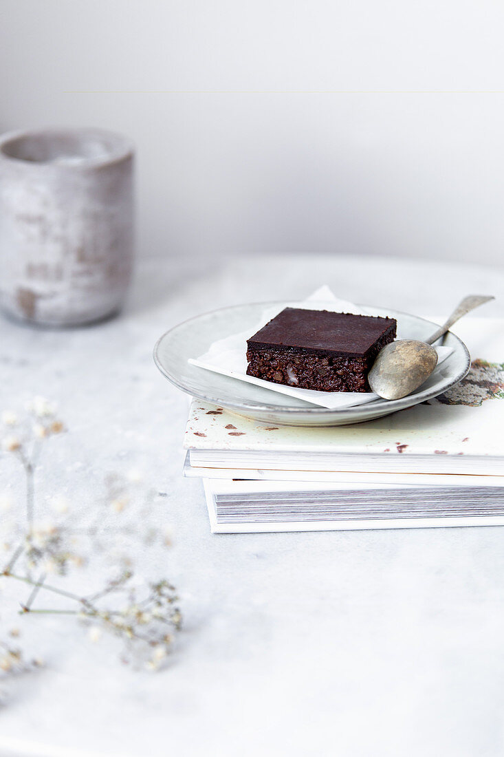 Vegan raw brownies with nuts and dates, on white marble background