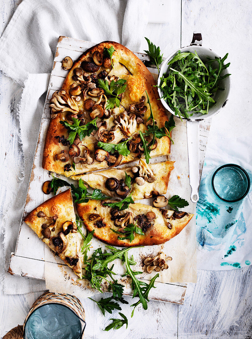 Pizza mit Knoblauchpilzen und Rucola