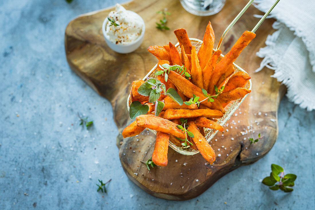 Spicy sweet potatoes fries with fresh herbs and salt flakes