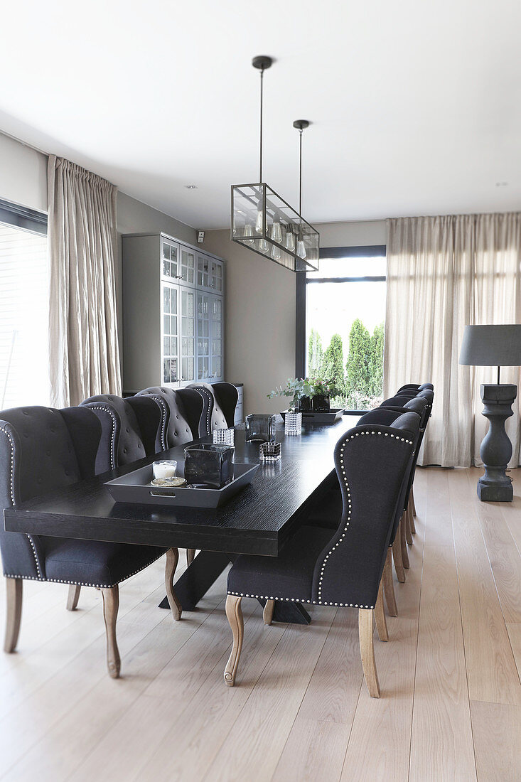 Elegant upholstered chairs around black table in dining area