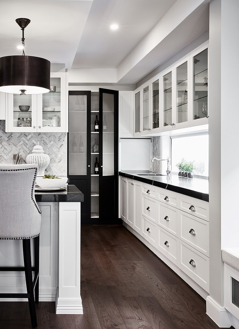 Weiße Küchenzeile mit schwarzer Arbeitsplatte in offener Küche