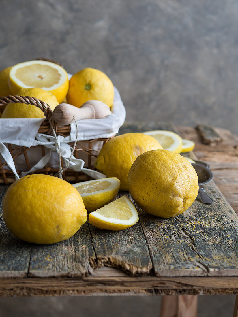 Lemons and citrus reamer placed on wooden board