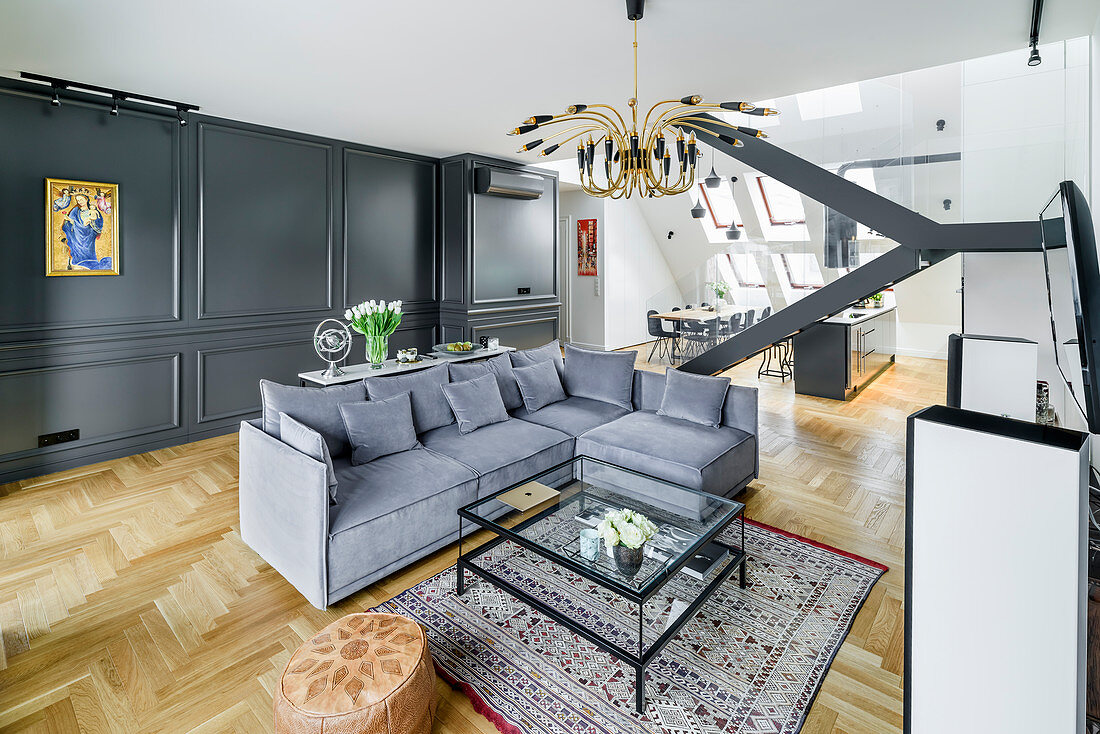 Sofagarnitur und Couchtisch aus Glas in elegantem Wohnraum mit dunkler Kassettenverkleidung
