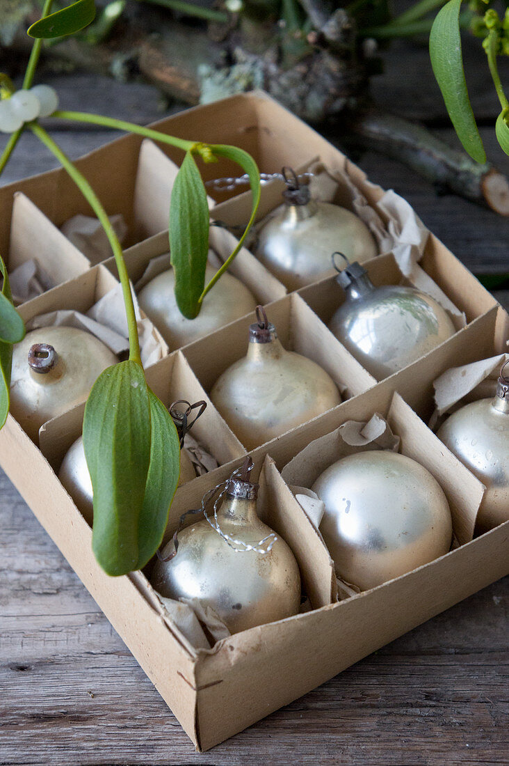 Box of old Christmas-tree baubles and mistletoe