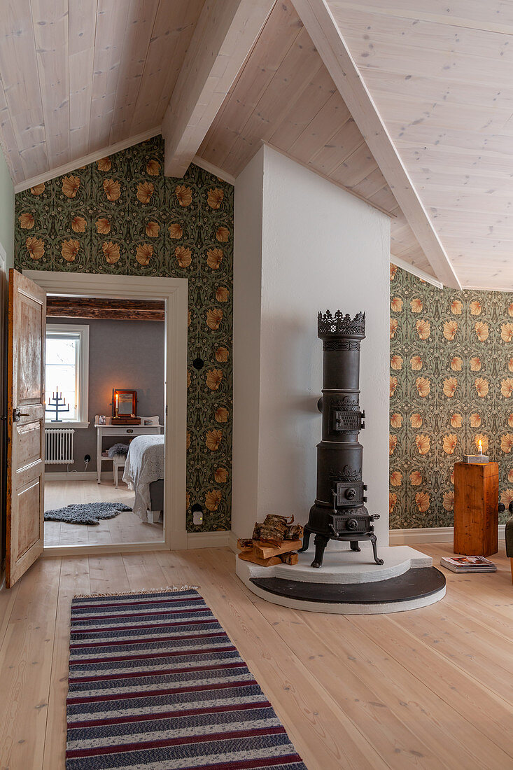 Antique wood-burning stove and William Morris wallpaper in airy living room