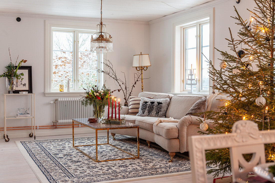 Decorated Christmas tree, pale couch and coffee table in living room