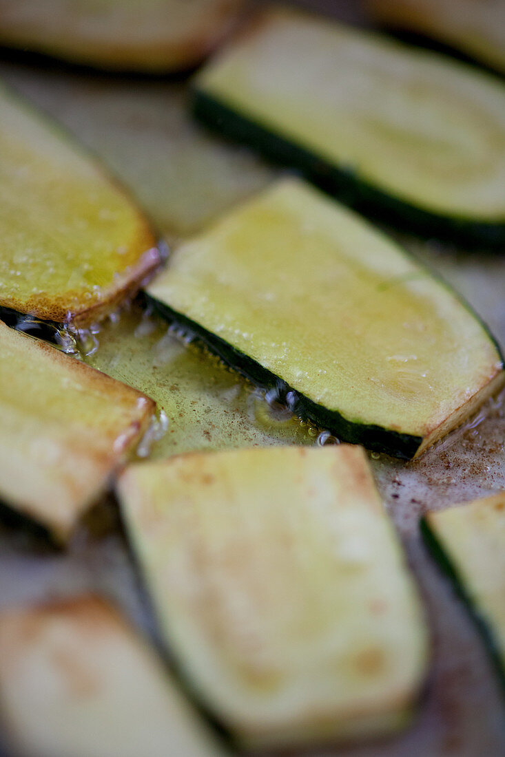 Courgette slices being roasted in oil